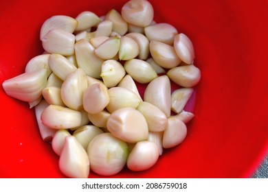 Peeled Garlic In A Red Plastic Bowl 