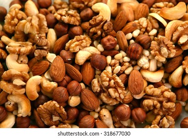 Peeled nuts in bulk as background: walnut, almonds, cashews