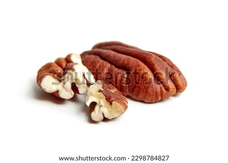 Peeled pecan nuts isolated on a white background. Heap of pecan halves closeup