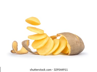Peeled potatoes with the skin as a spiral pieces of potatoes fall in the air on white background