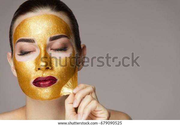 美しい顔の皮から金の仮面を剥ぐ の写真素材 今すぐ編集