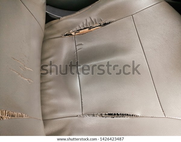peeling faux leather couch. A\
close-up of a damaged Gray faux leather.torn car cushion.Showing to\
the Gray leather car seat damaged corner. Problem Car seat\
cracking 