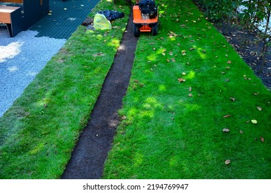 peeling grass carpets using a motorized peeler. replacement of grass sods as carpets. the worker coils the green belt into a ball. the knife of the machine undermines and cuts the roots from subsoil - Shutterstock ID 2194769947