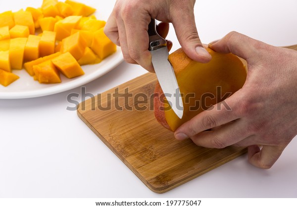 Peeling the middle Mango slice, which contains the\
fruit kernel