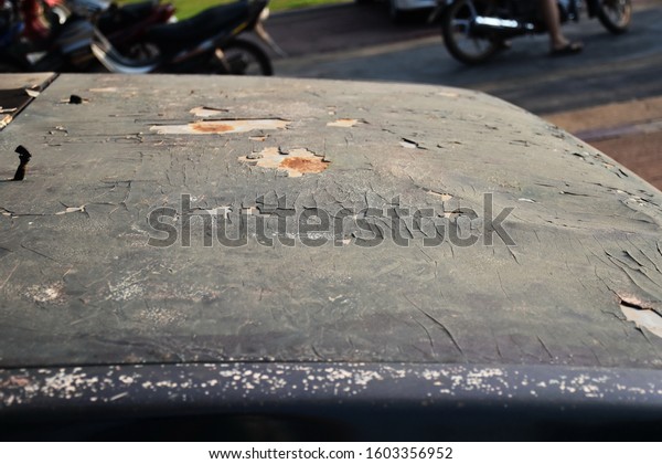 Peeling paint on the bonnet of\
the blue car Corrosion of metal on the car Chipping paint on metal\
surfaces, rust corrosion on the car bonnet, choose a specific\
focus.