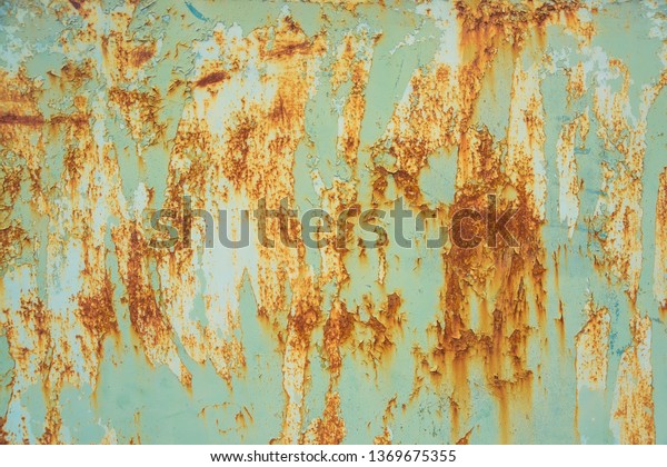 Peeling paint on the metal\
surface. Corrosion of metal on the car. Rusty painted metal\
texture.