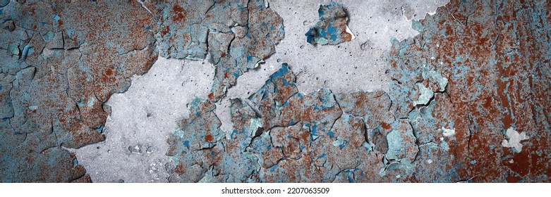 Peeling paint on the wall. Panorama of a concrete wall with old cracked flaking paint. Weathered rough painted surface with patterns of cracks and peeling. Wide panoramic texture for design background