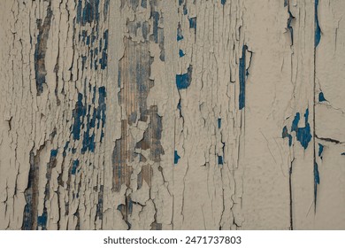 Peeling paint on a weathered wooden surface, revealing layers of blue and brown underneath. The texture shows significant wear and aging - Powered by Shutterstock