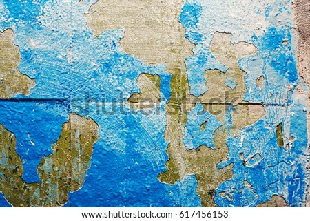 Peeling paint of white and blue colors on the stone texture background.