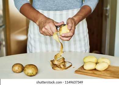 Peeling some potatoes on white table 