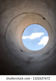 peeping the blue sky and clouds from inside of a hole or a tube