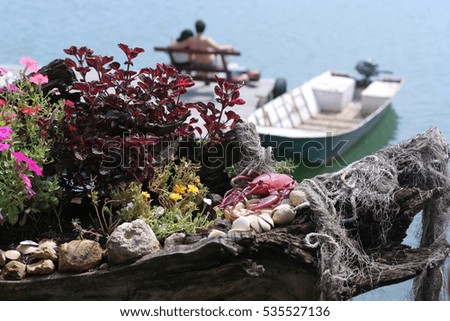 Peer with lobster and flowers in foreground and out of focus people in background
