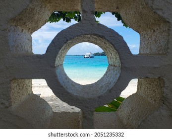 Peering Through A Port Hole At A Boat In Bora Bora