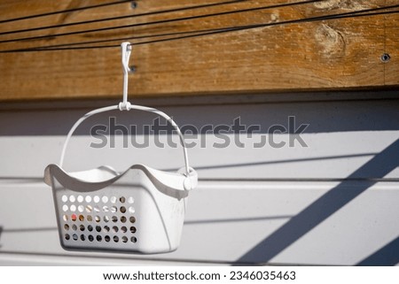 peg basket on clothesline with pegs in it