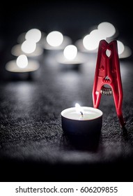 A Peg Which Looks Like A  Kissing Couple In Front Of A Candle Light