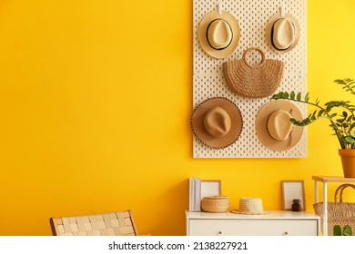 Pegboard With Hats And Bag Hanging On Yellow Wall