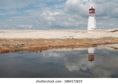 Peggy's lighthouse reflected in a puddle. Nova Scotia, Canada