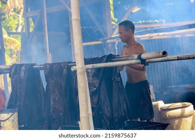 Pekalongan, Indonesia 13 02 2022
The activity of the man in the smoke is washing batik