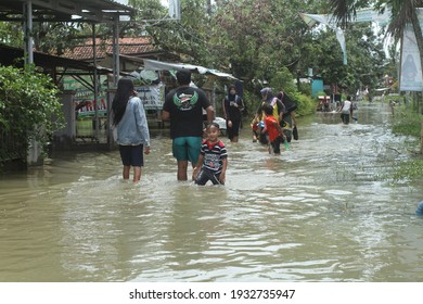 Pekalongan, Indonesia - February 21, 2021 : BLUR AND NOISE IMAGE OF residents walk across flooded roads