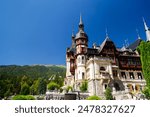 The Peles castle in the town of Sinaia, Transylvania, Carpathian Mountains, Romania, Summer time, bright sunny day with dark blue sky. The Peles castle is the most impressive castle in Romania.