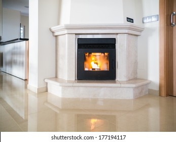 Pellet Fire Place Alight And Reflecting In A Polished Stone Floor