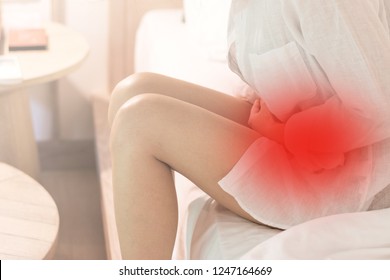 Pelvic pain stomachache medical healthcare concept. Hands of young woman on stomach as suffer from menstruation cramp, indigestion, gastrointestinal, diarrheas  or female diseases problem  
