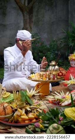 The Pemangku in Bali are carrying out a Hindu purification ceremony with several offerings addressed to God or Ida Sang Hyang Widi