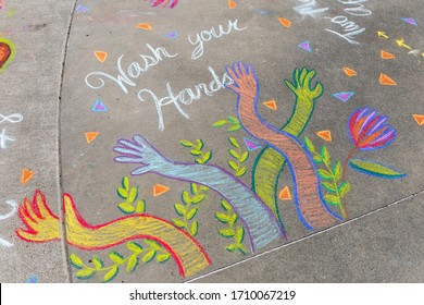 PEMBERTON, CANADA - MARCH 31, 2020: Wash Your Hands Is Written In Sidewalk Chalk On The Cement.