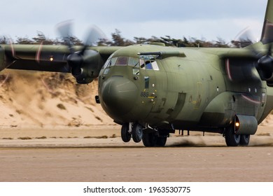 PEMBREY, WALES - APRIL 13 2021: A Royal Air Force Lockheed C-130J 'Super Hercules' performing tactical landings and takeoffs from the public beach at Cefn Sidan Sands in West Wales.
