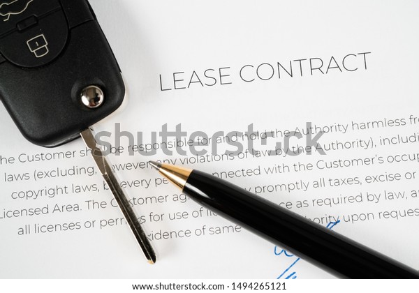 Pen\
and car key on a lease contract ready to be\
signed