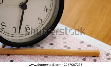 Pen and clock in optical reader. Exam idea.
Education and future concept. Middle and high school students will take the exam. Selective focus.