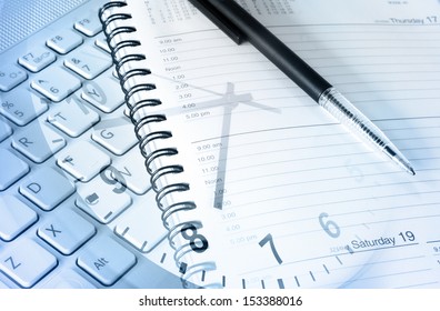 Pen, diary, clock and computer keyboard 