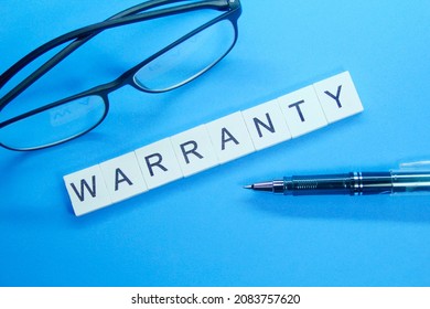 pen, glasses and word warranty on white compartment
