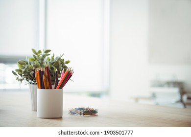 Pen Holder And Pot Plant On Table In Office