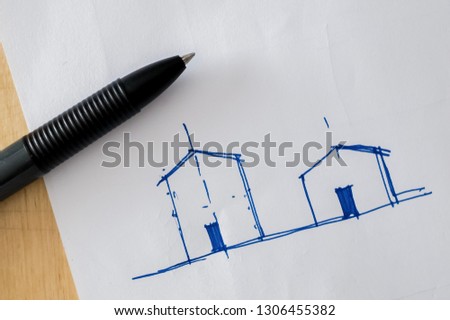 A pen lay down on a sketching paper. This paper was sketched for a proportion of the simply house facade in blue ink.