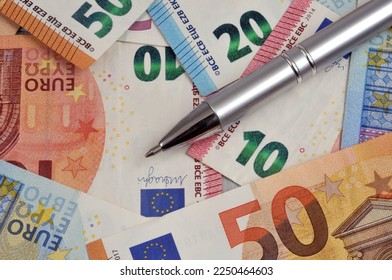 Pen lying on euro banknotes close up  - Shutterstock ID 2250464603