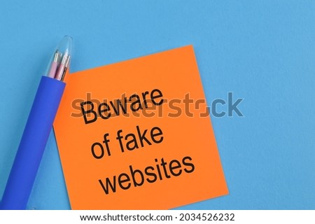 Pen and memo note written with text BEWARE OF FAKE WEBSITES