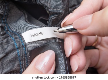 Pen In Mother's Hands For Fills The Name Label On Children's School Clothes. Child Name, Concept