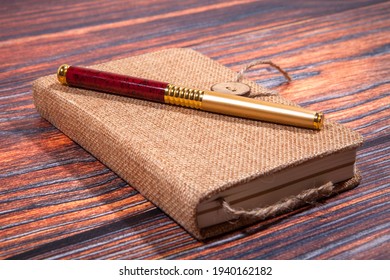 Pen and notebook close up on rustic wooden table. Close-up