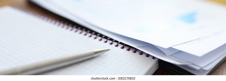 Pen with notebook and documents are on table