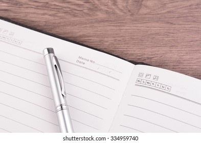 Pen and notepad on wooden table