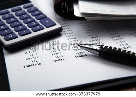 pen on background of calculator and accounting papers