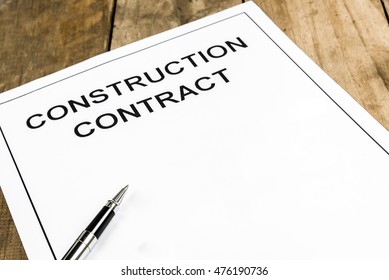 Pen On Construction Contract Paper On Wooden Table.