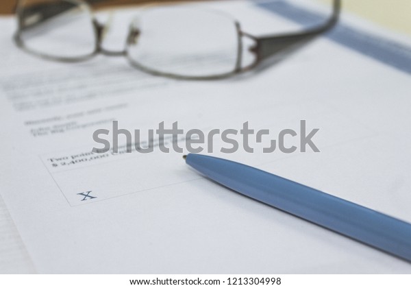 Pen on legal\
document awaiting\
signature.