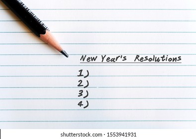 A Pen On A Lined Nite Paper, With Text Written NEW YEAR'S RESOLUTIONS And The Blank List- Concept Of Making Determined Resolutions To Change In The Next Coming Year