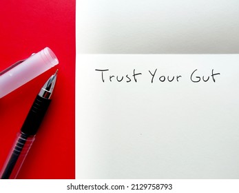 Pen on notebook with handwritten text TRUST YOUR GUT refers to trusting feelings of intuition,Following  instinct, can be valuable tool in some circumstances