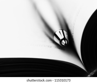 Pen on a opened book. Macro image.