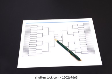 A Pen On Top Of An Blank March Madness Tournament Bracket