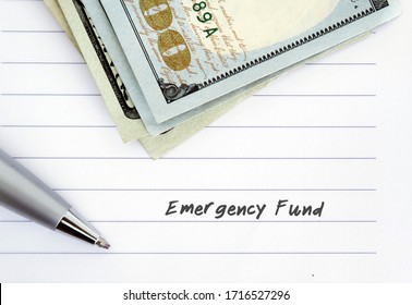 A Pen On White Lined Note Paper With Cash Dollars Money - With Text Written EMERGENCY FUND - Concept Of Financial Personal Plan To Save Money For Emergency Expenses Crisis Tough Time Rainy Day