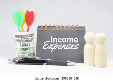 Pen, Peg Doll, Notebook, Paper Money With The Word Income Expenses